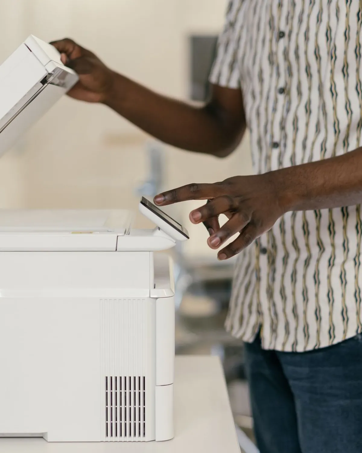 Person placing a document into an office scanner